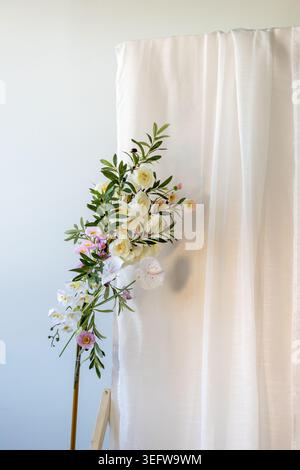 A collection of various flowers is positioned next to a white curtain. The scene shows natural light coming through the curtain, highlighting the flow Stock Photo
