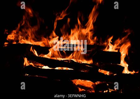Fire embers particles over black background. Fire sparks background. Abstract dark glitter fire particles lights. Stock Photo