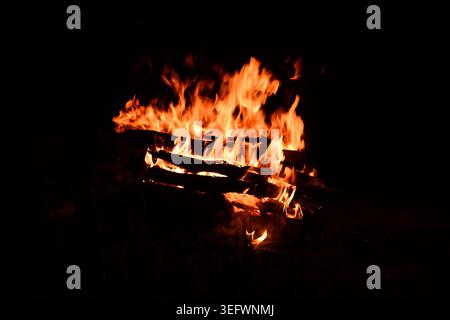 Fire embers particles over black background. Fire sparks background. Abstract dark glitter fire particles lights. Stock Photo