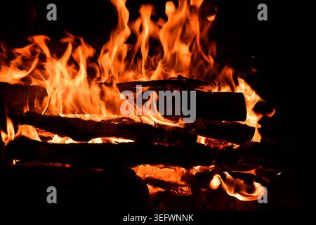 Fire embers particles over black background. Fire sparks background. Abstract dark glitter fire particles lights. Stock Photo