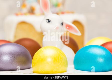 Traditional Easter dinner or brunch with ham, colored eggs, hot cross buns, cake and vegetables. Easter meal dishes with holday decorations. Stock Photo