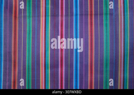 Close-up texture of colorful woven plastic material with vertical stripes. Stock Photo