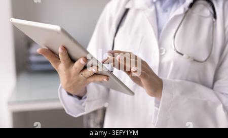 Doctor working on digital tablet in clinic office, close up Stock Photo