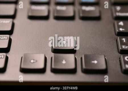 Angled Top View Macro Close-Up Black Keyboard Highlighting Up Arrow Key with Soft Blurred Tech Backgrounds Stock Photo