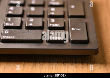 Angled Top View Macro Close-Up Black Computer Keyboard Highlighting Delete Key on Numeric Keypad on Blurred Tech Backgrounds Stock Photo