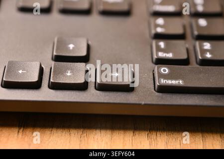 Angled Top View Macro Close-Up Black Computer Keyboard Highlighting Right Arrow Key on Blurred Tech Backgrounds Stock Photo