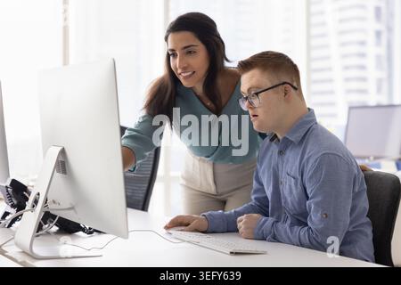 Two diverse teammates working on joint project in office Stock Photo