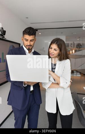 Two business colleagues discussing data on laptop Stock Photo