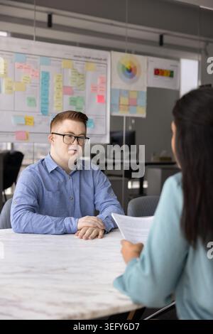 Job interview with young man with Down syndrome in office Stock Photo