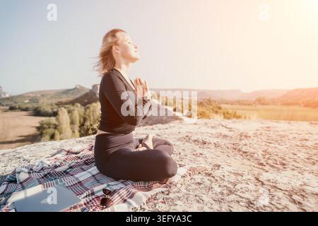 Woman Meditating on a Mountaintop Stock Photo