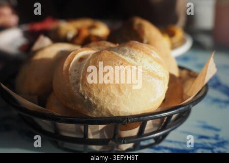 Fresh rolls in a basket on a dining table Stock Photo
