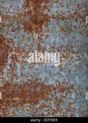 Closeup of a blue metal surface with intense orange rust patches, flaking paint, and rough texture. Weathered, industrial, and rugged, conveying decay Stock Photo
