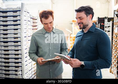 Warehouse managers collaborating on inventory using digital tablet Stock Photo