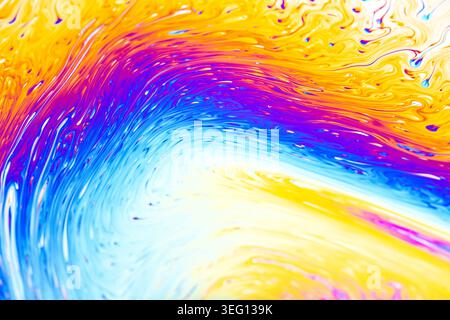 Close-up view of iridescent soap bubble film showing interference patterns and fluid dynamics in a spectrum of colors Stock Photo