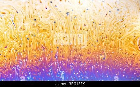 Close-up view of a soap film's interference colors, showcasing swirling patterns and fluid dynamics Stock Photo