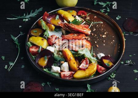 Colorful roasted peach and beet salad with arugula and feta on rustic plate Stock Photo