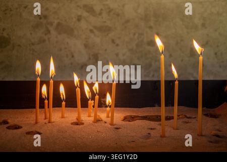Burning candles in the sand Stock Photo