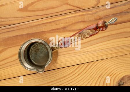 Copper coffee pot on a wooden table, close-up. Top view. Stock Photo