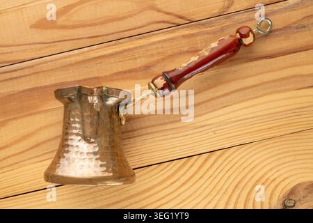 Copper coffee pot on a wooden table, close-up. Top view. Stock Photo
