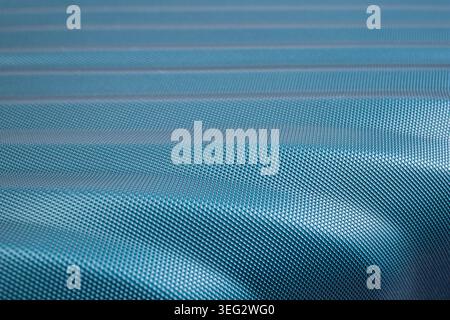Waved turquoise carbon fiber plastic texture, surface detail close up , abstract patterned  wallpaper Stock Photo