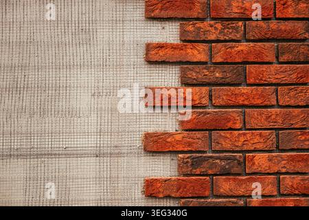 Red brick wall texture partially exposed over plaster background for construction and design Stock Photo