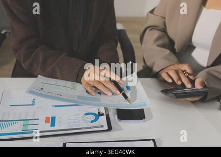 Two young Asian businesswomen discuss investment project working and ...