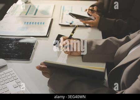 Two young Asian businesswomen discuss investment project working and ...
