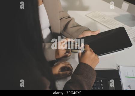 Two young Asian businesswomen discuss investment project working and ...
