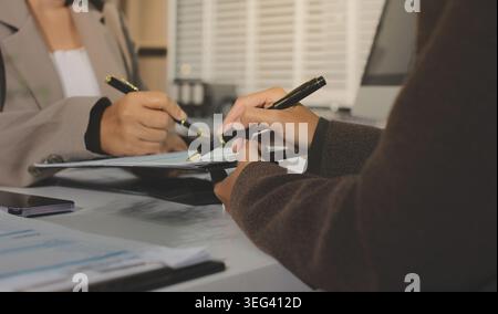 Two young Asian businesswomen discuss investment project working and ...