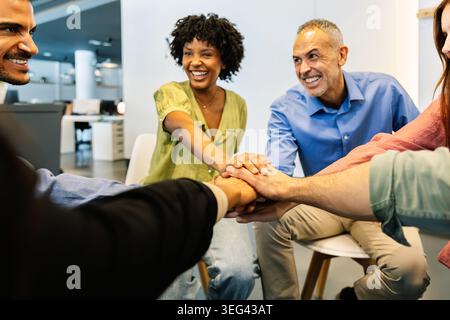 Diverse business team stacking hands for collaboration Stock Photo
