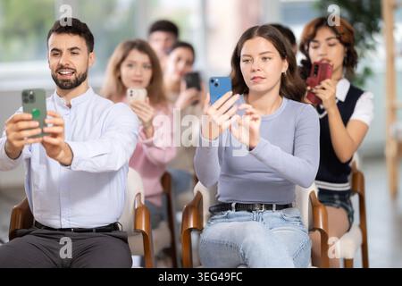 Students using mobile phones to scan QR code during interactive lesson Stock Photo