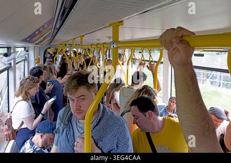 Crowded Manchester Metrolink tram in the city centre, commuters standing on Bee Network light rail linked with Andy Burnham Stock Photo