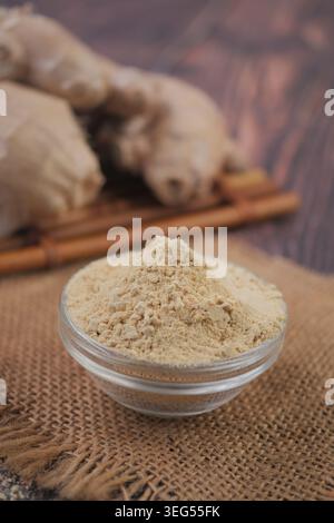 Ginger powder placed in a glass bowl on a wooden table Stock Photo