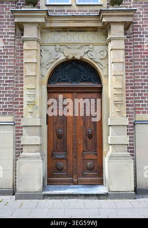 Old wooden door on the façade of a house in Neuss, Germany Stock Photo