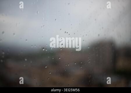 Raindrops on a window. The drops are small and scattered. The window is clear and the rain is falling Stock Photo