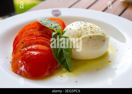 Insalata Caprese - Mozzarella & Pomodori & Basil - on white plate, Italy. Stock Photo