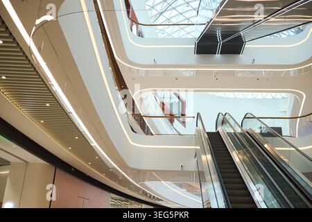Modern Shopping Mall Interior Featuring Escalators and Retail Space Stock Photo