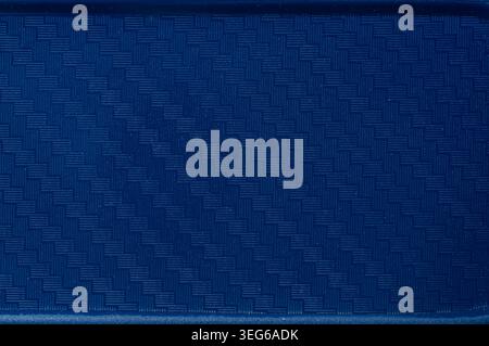 A close-up view of a dark blue material featuring a repeating geometric weave pattern, creating a tactile and visually interesting background Stock Photo