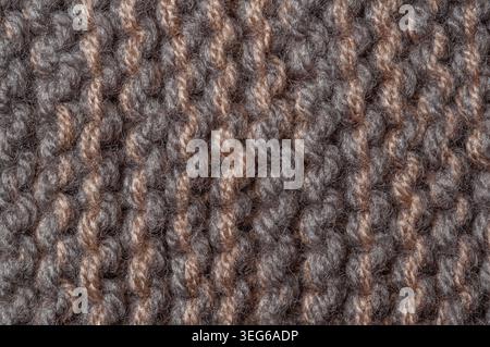 Detailed texture of a woven textile showing the intricate pattern of interlaced fibers in a warm color palette Stock Photo