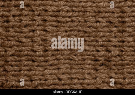 Detailed view of a vibrant brown knitted textile, showcasing the intricate weave and fuzzy texture of the wool or acrylic yarn fibers Stock Photo