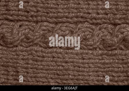 Detailed view of a vibrant brown knitted textile showcasing a distinct cable knit pattern and ribbed texture, perfect for craft or fashion concepts Stock Photo
