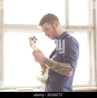 Handsome man playing on guitar Stock Photo