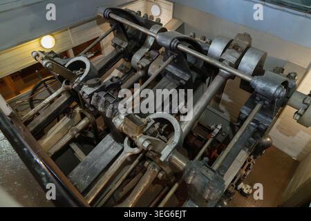 Top view of historic steam engine mechanism inside vintage river steamboat. Metal rods, cylinders and mechanical machine parts representing industrial Stock Photo