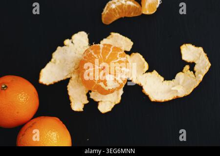 Shelled mandarins on a black background Stock Photo