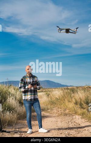 The pilot observes his drone in mid-flight while practicing. Stock Photo