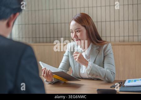 Asian businesswoman taking notes during professional business meeting Stock Photo