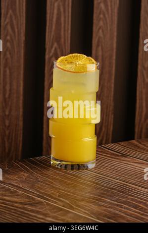 Modern yellow cocktail with orange slice on wood Stock Photo