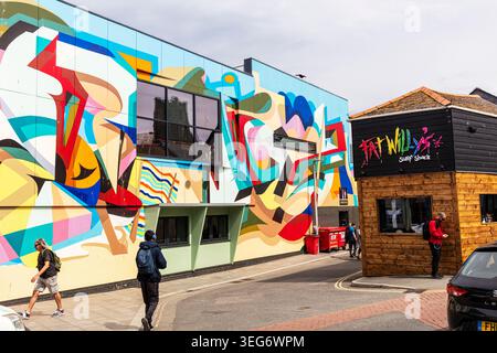 Newquay, Cornwall, UK, England, Street scene in Newquay, Cornwall, featuring a large colourful abstract mural covering the side of a building beside Stock Photo