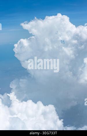 Large, puffy cumulus clouds. Blue sky with scattered white cumulus clouds. Clouds, a view from airplane window. Sky-clouds background Stock Photo
