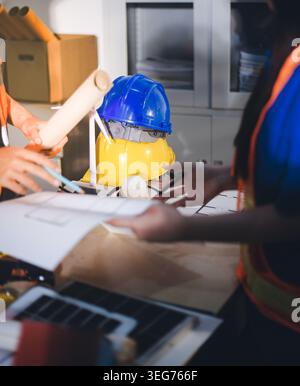 Two technicians inspect server racks in data center with tablet and fiber optic cable. Engineer and specialist discuss maintenance work in data center Stock Photo